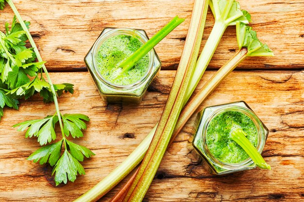 Smoothie vert d'été sain et appétissant à base de tiges de rhubarbe et d'herbes.