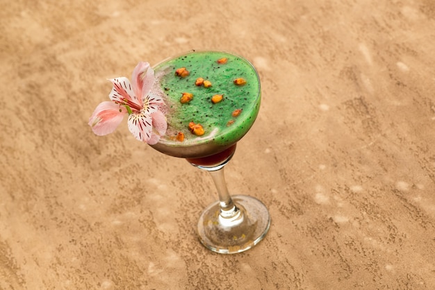 Smoothie vert sur fond marron clair