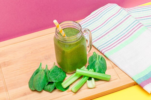 Smoothie vert frais de céleri aux pommes et d'épinards dans un pot de smoothie en verre