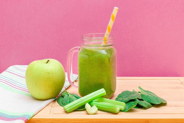 Smoothie vert frais de céleri aux pommes et d'épinards dans un pot de smoothie en verre