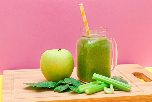 Smoothie vert frais de céleri aux pommes et d'épinards dans un pot de smoothie en verre