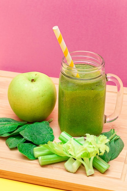 Smoothie vert frais de céleri aux pommes et d'épinards dans un pot de smoothie en verre