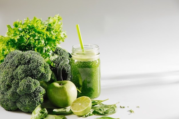 Smoothie vert mélangé frais en pot sur tableau blanc