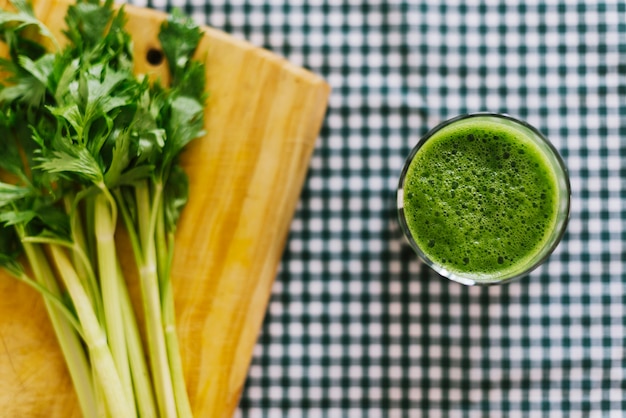 Smoothie vert près du céleri sur planche à découper