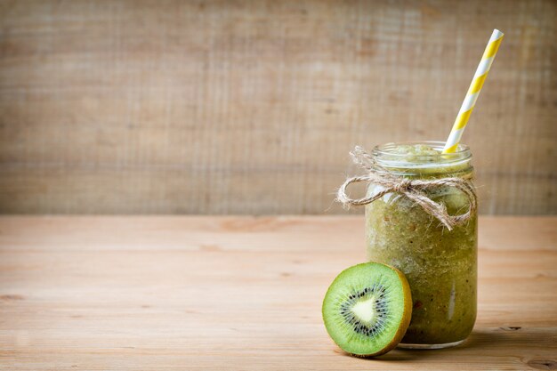 Photo smoothie vert sain dans un verre sur du vieux bois.