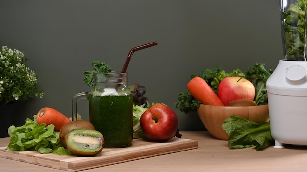 Smoothie vert sain avec fruits et légumes sur table en bois