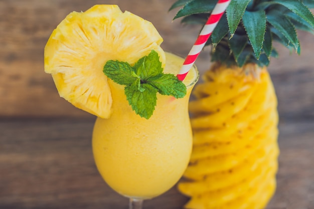 Smoothies ananas et ananas sur un vieux fond en bois