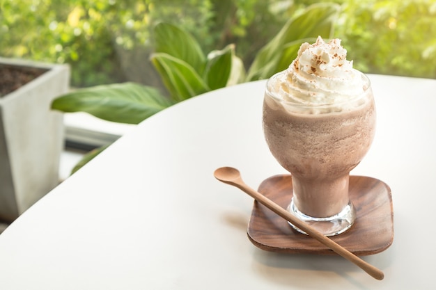 Photo smoothies au chocolat garnis de crème fouettée et de poudre de cacao.