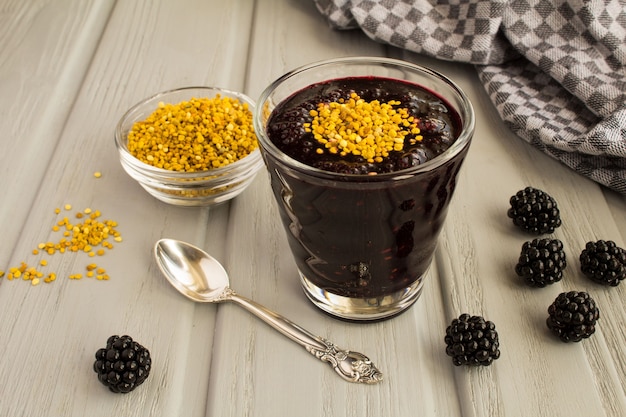 Smoothies au pollen de mûre et d'abeille sur le fond en bois gris