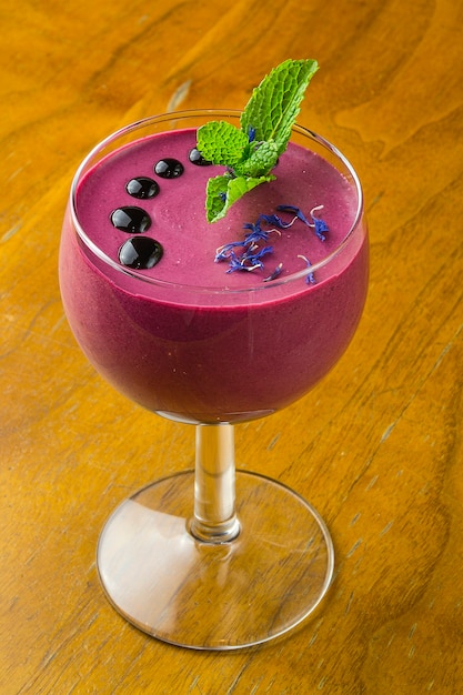 Smoothies aux bleuets dans un verre, sur une table en bois