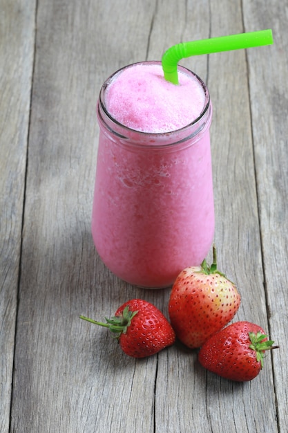 Smoothies aux fraises dans le verre sur le sol de la table des aliments.