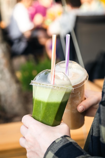 Smoothies aux fruits dans les mains d'un homme lors d'une fête d'été en gros plan