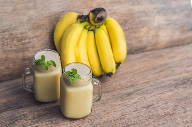 Smoothies à la banane et bananes sur un vieux fond en bois