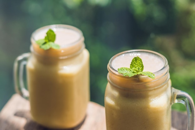 Smoothies à la banane et bananes sur un vieux fond en bois