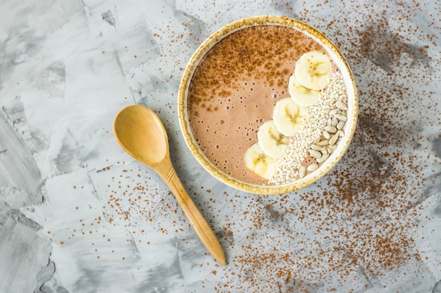 Smoothies chocolat-banane dans un bol sur un fond de béton gris