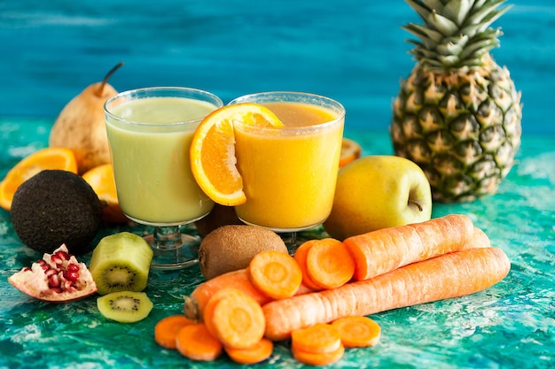 Smoothies détox frais bio entourés de fruits et légumes sur fond de bois