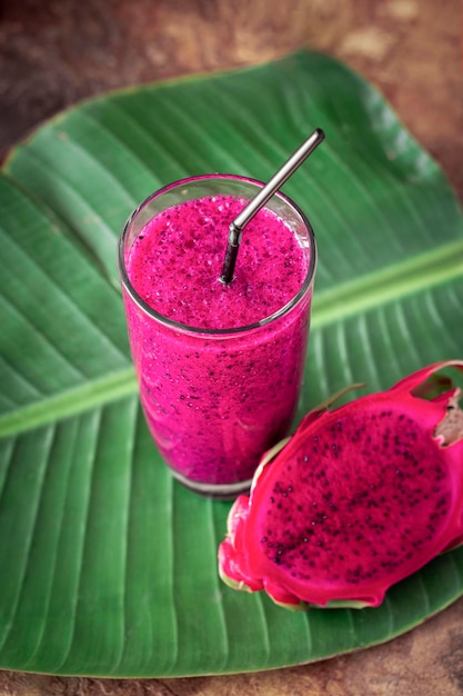 Smoothies frais d'un fruit du dragon dans du jus de verre et de la pitahaya fraîche sur fond tropical