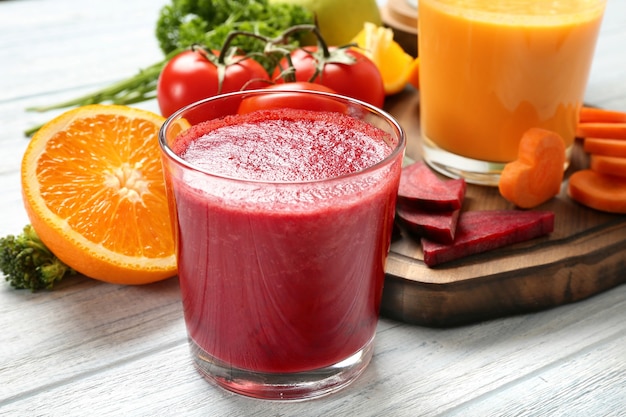 Smoothies frais, légumes et tranche d'orange sur table