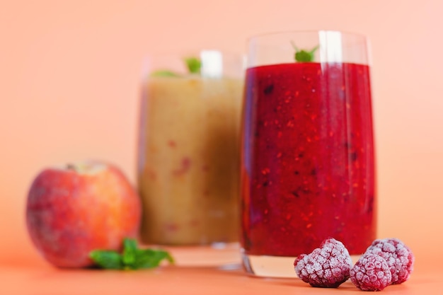 smoothies frais et sains dans des verres à base de pêche, de banane et de baies à la menthe. boisson détox, régime