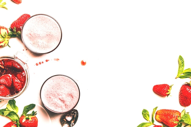 Smoothies laitiers aux fraises avec confiture de baies et de menthe verte fond blanc copie espace vue de dessus