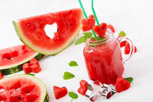 Smoothies pastèque fraîche à la menthe sur une table en bois blanc.