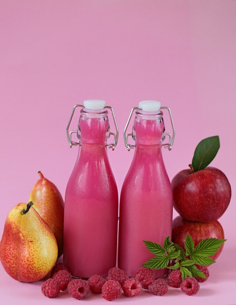 Smoothies roses à base de pommes fraîches, de poires et de framboises aux baies roses.