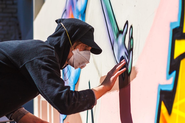 Photo smorgon bélarus 16 août 2009 un jeune homme dans un respirateur dessine des graffitis sur le mur