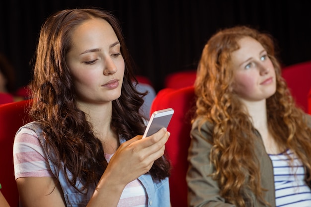 SMS de femme sur son téléphone portable pendant le film