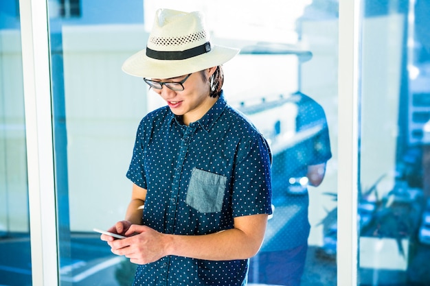 SMS d&#39;homme d&#39;affaires hipster souriant dans son bureau