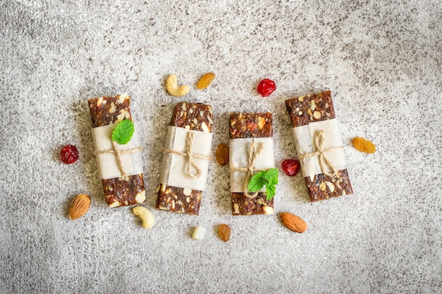 Snack-bars sains de fruits secs et de noix sur fond gris. Vue de dessus