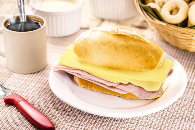 Snack brésilien typique pao de sal avec du fromage mozzarella en tranches et du pain français au jambon pour le petit déjeuner