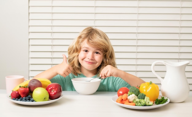 Snack du matin avec muesli céréales granola Petit enfant garçon prenant un petit déjeuner sain Nutrition et développement des enfants Manger des légumes par l'enfant les rend plus sains