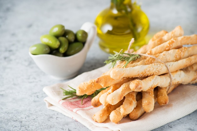 Snack-gressins italiens traditionnels à l'huile d'olive et aux graines de sésame sur fond clair, mise au point sélective