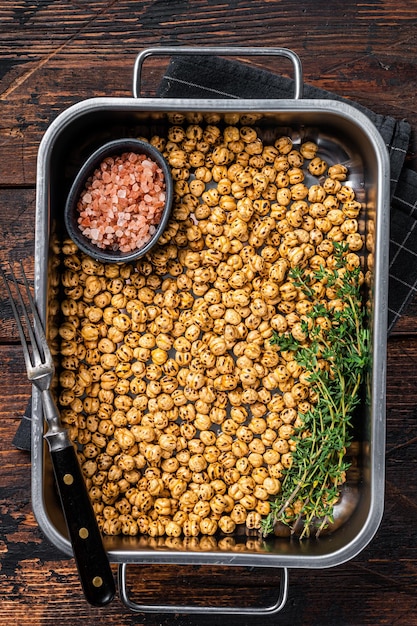 Snack végétarien de pois chiches épicés frits dans un plateau de cuisine. Fond en bois. Vue de dessus.