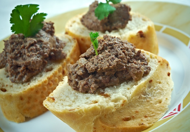 Snack de viande maison pâté de foie de poulet avec du pain sur une table en bois