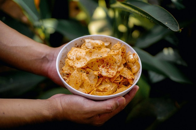 Snacks épicés qui sont dans le bol porté par les deux mains