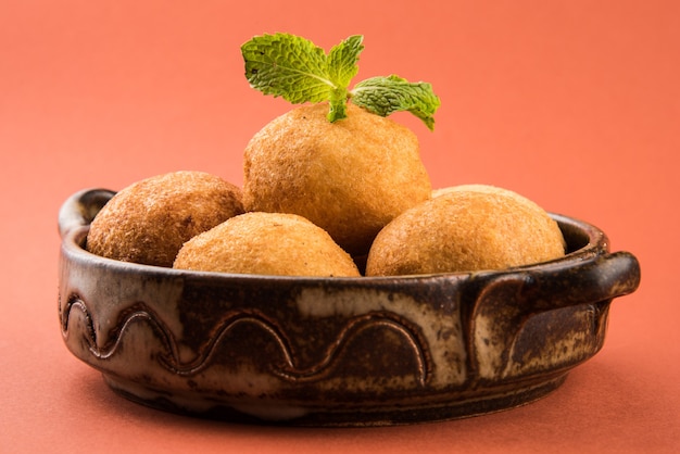 Snacks indiens Aloo Bonda ou batata vada ou urad daal vada ou pakoda ou pakora. Servi avec chutney vert. Mise au point sélective