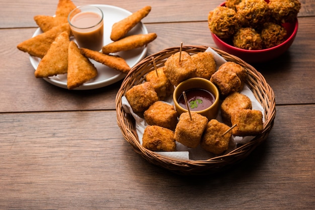 Snacks indiens Triangles de pommes de terre croustillantes, Paneer Lollipop et nouilles pakoda en groupe