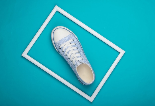 Une sneaker rétro sur surface bleue avec cadre blanc