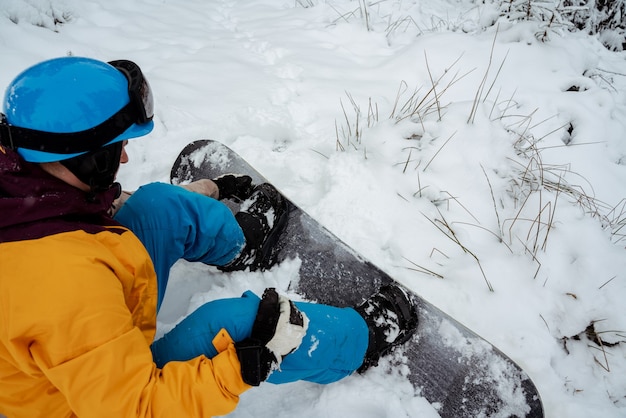 Snowboarder assis seul dans la neige, montagne en plein air, activité de sports d'hiver.