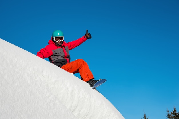 Snowboarder au repos au sommet de la montagne