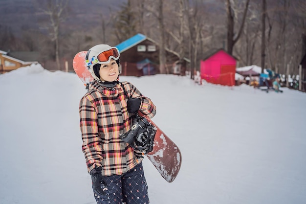 Snowboarder femme sur une journée d'hiver ensoleillée dans une station de ski