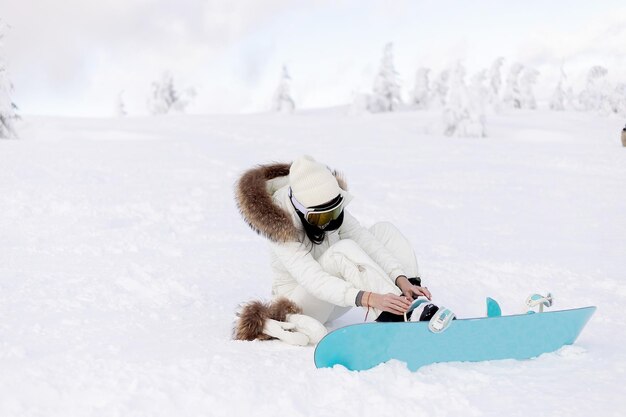 Snowboarder femme sur les pistes par une journée d'hiver glaciale