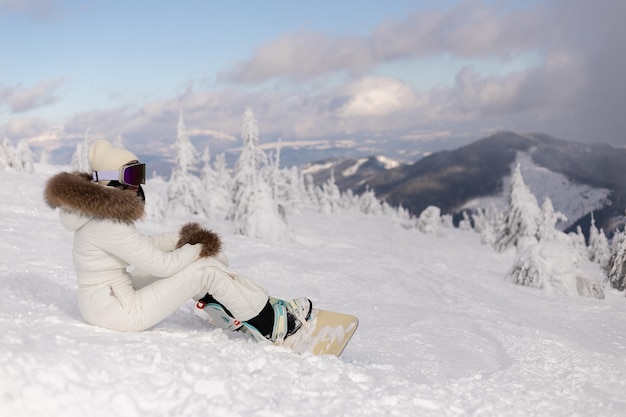 Snowboarder femme sur les pistes par une journée d'hiver glaciale