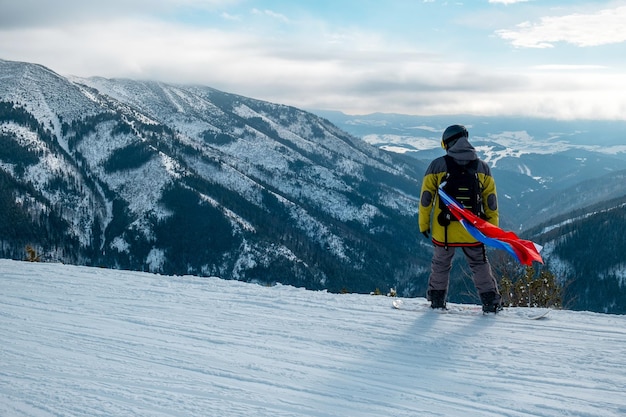 Snowboarder homme avec le drapeau de la slovaquie sur la pente de la station de ski