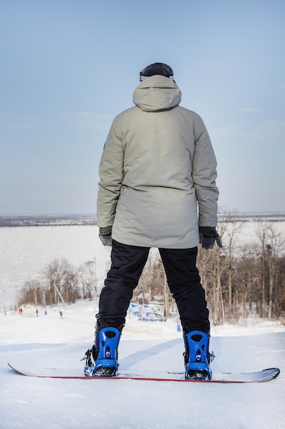 Snowboarder masculin au sommet de la vue arrière de la piste de ski Pas de visage Photo verticale