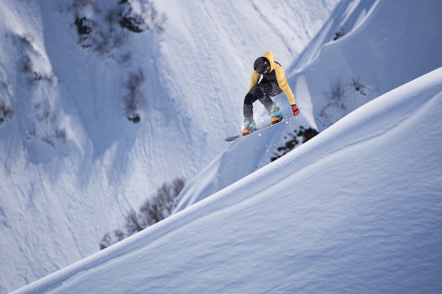 Snowboarder volant sur les montagnes.