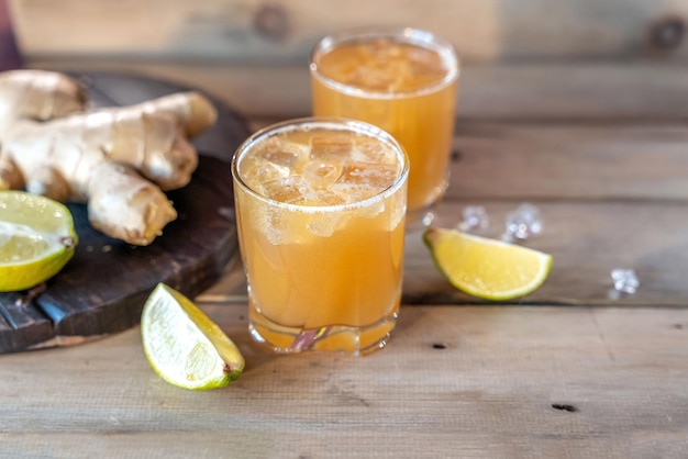 Soda au gingembre biologique dans un verre avec du citron et de la lime Photo de haute qualité