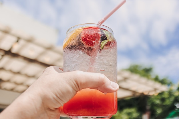 Soda italien rose de fruits mélangés contre le ciel ensoleillé d'été