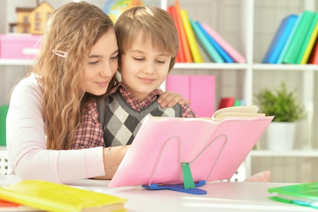 Sœur aidant son frère à faire ses devoirs